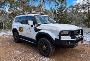 A FleetCrew Prado 250 Series with ski racks in a snowy clearing